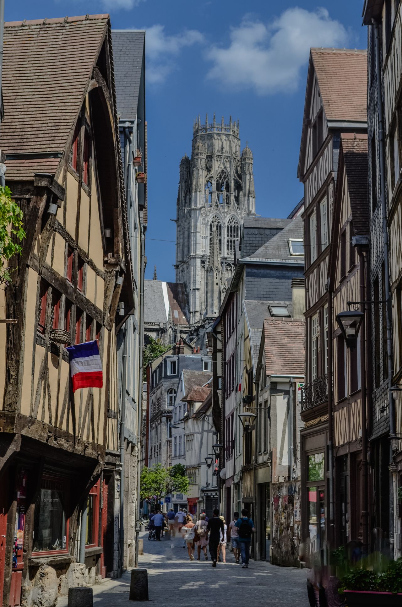 Historic street in Rouen leading to the cathedral under a clear summer sky